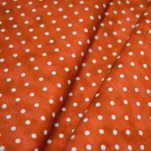 Tela marmoleada de topos blancos con fondo naranja. TROY